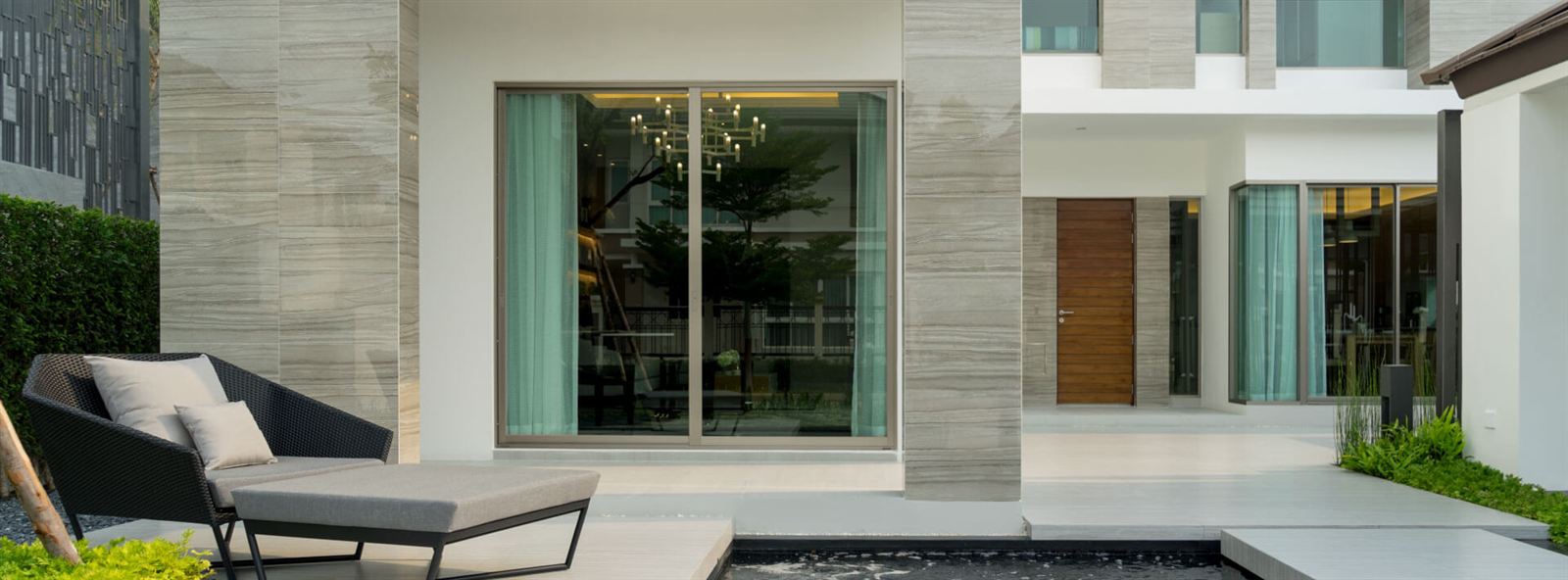 บ้านตัวอย่างสไตล์โมเดิร์น ผนังหินและกระจกบานใหญ่เปิดสู่สวน